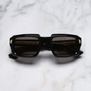 An image of the Palace Cutler and Gross Jupiter Rectangle Sunglasses in 18k Gold Black frame frontal view with arms closed marble background