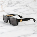 An image of the Palace Cutler and Gross Jupiter Rectangle Sunglasses in 18k Gold Black frame side view with arms open marble background