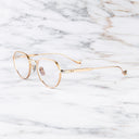 An image of the Pelham 1430 Round Opticals in Pink Gold/Silver frame side view with arms open marble background