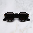 An image of the Palace Cutler and Gross Victory Round Sunglasses in Black frame frontal view with arms closed marble background