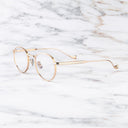 An image of the Lennox 1428 Round Opticals in Pink Gold/Silver frame side view with arms open marble background