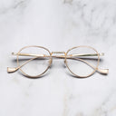 An image of the Lennox 1428 Round Opticals in Pink Gold/Silver frame frontal view with arms closed marble background
