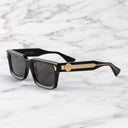 An image of the Palace Cutler and Gross Mercury Square Sunglasses in Black frame side view with arms open marble background