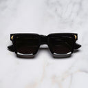 An image of the Palace Cutler and Gross Mercury Square Sunglasses in Black frame frontal view with arms closed marble background