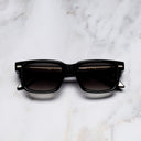 An image of the Breitling Cloudbreak 0004 Rectangle Sunglasses in Black frame frontal view with arms closed marble background