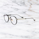 An image of the Lennox 1428 Round Opticals in Black/Gold frame side view with arms open marble background