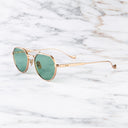 An image of the Draycott 1426 Round Sunglasses in Jewel Gold frame side view with arms open marble background