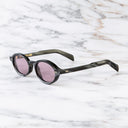 An image of the GR13 Oval Sunglasses in Black Horn frame side view with arms open marble background