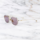 An image of the Draycott 1426 Round Sunglasses in Silver/Gold frame side view with arms open marble background