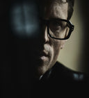 Image of male model wearing the 9852 Optical in Black. The image has a shadow on the right hand side of his face.