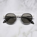 An image of the Breitling Chrono 0002 Round Sunglasses Black frame frontal view with arms closed marble background