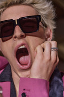 Image of male model wearing the Great Frog Flex Sunglasses, he is also wearing from Great Frog rings, a pink blazer, and has his mouth open.