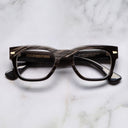An image of the Cutler and Gross 0772V1 Square Horn Optical in Smoke Brown/Cream Buffalo Horn frame frontal view with arms closed marble background
