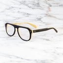An image of the Cutler and Gross 0822V2 Aviator Horn Optical in Deep Black/Cream Buffalo Horn frame side view with arms open marble background