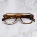 An image of the Cutler and Gross 0822V2 Aviator Horn Optical in Amber Buffalo Horn frame frontal view with arms closed marble background
