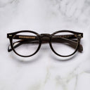 An image of the Cutler and Gross 1378 Round Horn Optical in Smoke Brown/Cream Buffalo Horn frame frontal view with arms closed marble background