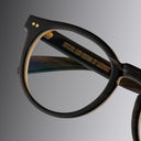 An image of the Cutler and Gross 1378 Round Horn Optical in Smoke Brown/Cream Buffalo Horn frame detail close up of left lens and temple
