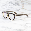 An image of the Cutler and Gross 1378 Round Horn Optical in Smoke Brown/Cream Buffalo Horn frame side view with arms open marble background