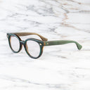 An image of the Cutler and Gross 9298 Round Horn Optical in Moss Green/Brown Buffalo Horn frame side view with arms open marble background