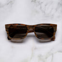An image of the Cutler and Gross 1214 Rectangular Horn Sunglass in Speckled Brown Buffalo Horn frame frontal view with arms closed marble background