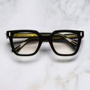 An image of the 1305 Square Opticals in Yellow on Black frame frontal view with arms closed marble background