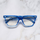 An image of the 1346 Cat Eye Opticals in Blue Crystal frame frontal view with arms closed marble background