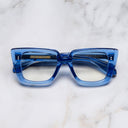 An image of the 1401 Cat Eye Opticals  Blue Crystal frame frontal view with arms closed Marble background