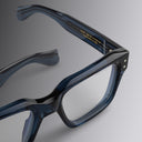 Cutler and Gross acetate blue eyeglasses on a gray background