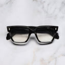 An image of the 9347 Square Opticals in Obsidian frame frontal view with arms closed marble background
