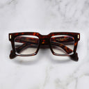An image of the 9386 Square Optical in Dark Turtle frame frontal view with arms closed marble background