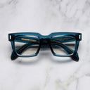 An image of the 9386 Square Optical in Deep Teal frame frontal view with arms closed marble background
