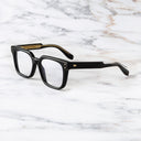 An image of the Cutler and Gross 9387 Square Optical frame in Black frame side view with arms open marble background.
