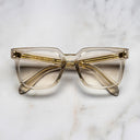 An image of the Cutler and Gross 9387 Square Optical frame in Sand Crystal frontal view with arms closed in marble background.