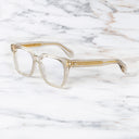 An image of the Cutler and Gross 9387 Square Optical frame in Sand Crystal side view with arms open marble background.