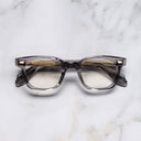 An image of the 9521 Square Opticals (Small) in Smoke Quartz frame frontal view with arms closed marble background