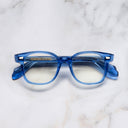 An image of the 9990 Round Opticals in Blue Crystal frame frontal view with arms closed marble background