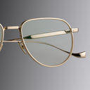 A Close Up image of Cutler and Gross Titanium Gold Optical Frame Featured on Gradient Grey Background