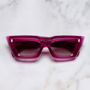 An image of the 1408 Cat Eye Sunglasses in Fuchsia frame frontal view with arms closed marble background