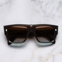 An image of the 1414 Rectangle Sunglasses in Dark Brown Crystal frame frontal view with arms closed marble background
