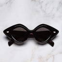 An image of the 9126 Oversize Sunglasses in Black on Pink frame frontal view with arms closed marble background