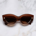 An image of the 9317 Cat Eye Sunglasses in Burnt Sunset frame frontal view with arms closed marble background