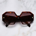 An image of the 9324 Square Sunglasses in Dark Turtle frame frontal view with arms closed marble background