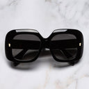 An image of the 9891 Rectangle Sunglasses in Black on Crystal frame frontal view with arms closed marble background