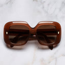 An image of the 9891 Rectangle Sunglasses in Burnt Sunset frame frontal view with arms closed marble background