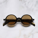 An image of the GR01 Round Sunglasses in Black on Camu frame frontal view with arms closed marble background