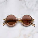 An image of the GR01 Round Sunglasses in Granny Chic frame frontal view with arms closed marble background