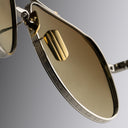 A close up image of Cutler and Gross gold titanium sunglasses with brown lenses from Serpentine SS26 collection.