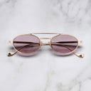 An image of the Ladbroke 1427 Oval Sunglasses in Pink Gold frame frontal view with arms closed marble background