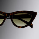 Tortoiseshell cat-eye sunglasses on a gradient gray background