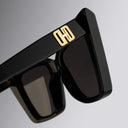 An image of the Cutler and Gross Valentina 002 Cat Eye Sunglasses frame detail close up of right hinge and temple with gold logo.